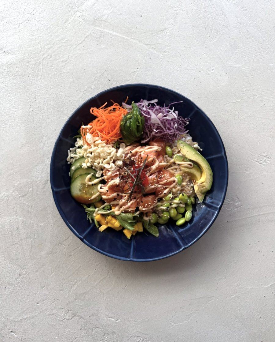 Chef preparing poke bowl in open kitchen counter at Montreal restaurant